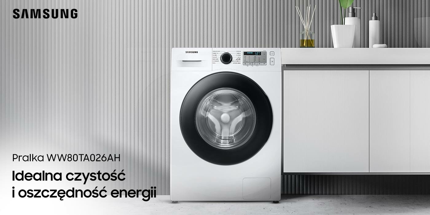 Pralka Samsung WW80TA026AH z czarną ramą drzwi, na tle szarej ściany, obok białych łazienkowych szafek Pralka Samsung WW80TA026AH z czarną ramą drzwi, na tle szarej ściany, obok białych łazienkowych szafek