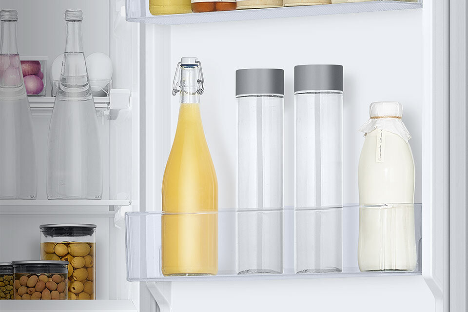 Sok, butelki wody i mleko na półkach drzwiowych Sok, butelki wody i mleko na półkach drzwiowych