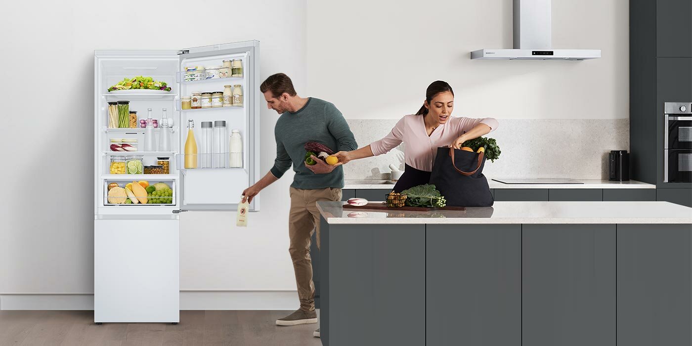 Para wypakowująca zakupy z płóciennej torby do lodówki Para wypakowująca zakupy z płóciennej torby do lodówki