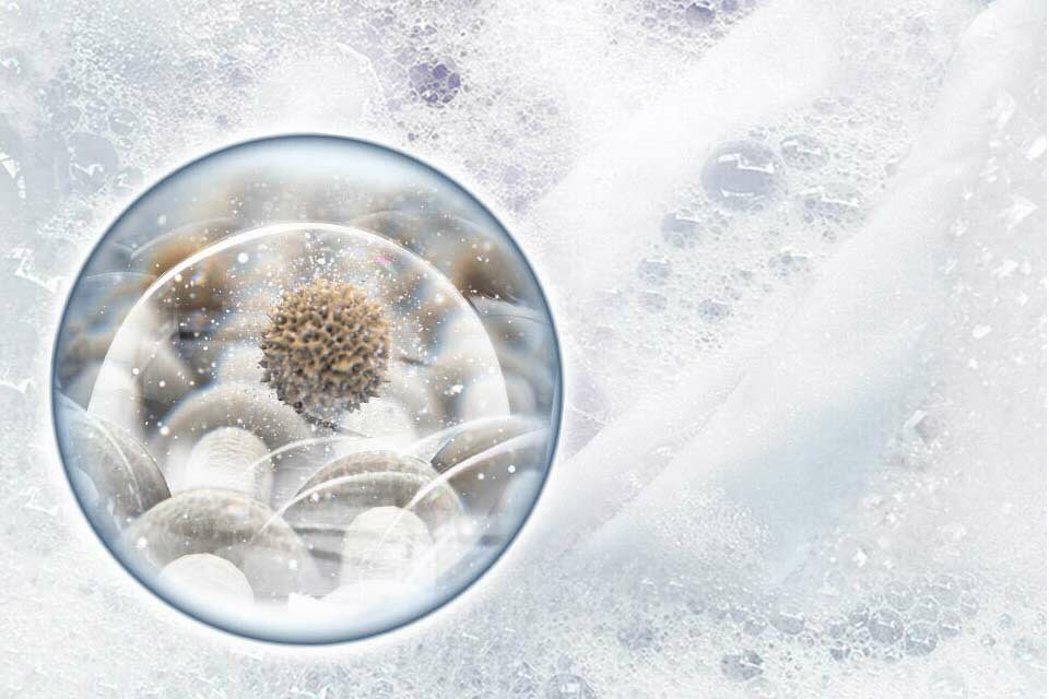 Piana, a wśród niej zbliżenie na zamkniętą w bąblu piany cząsteczkę brudu Piana, a wśród niej zbliżenie na zamkniętą w bąblu piany cząsteczkę brudu