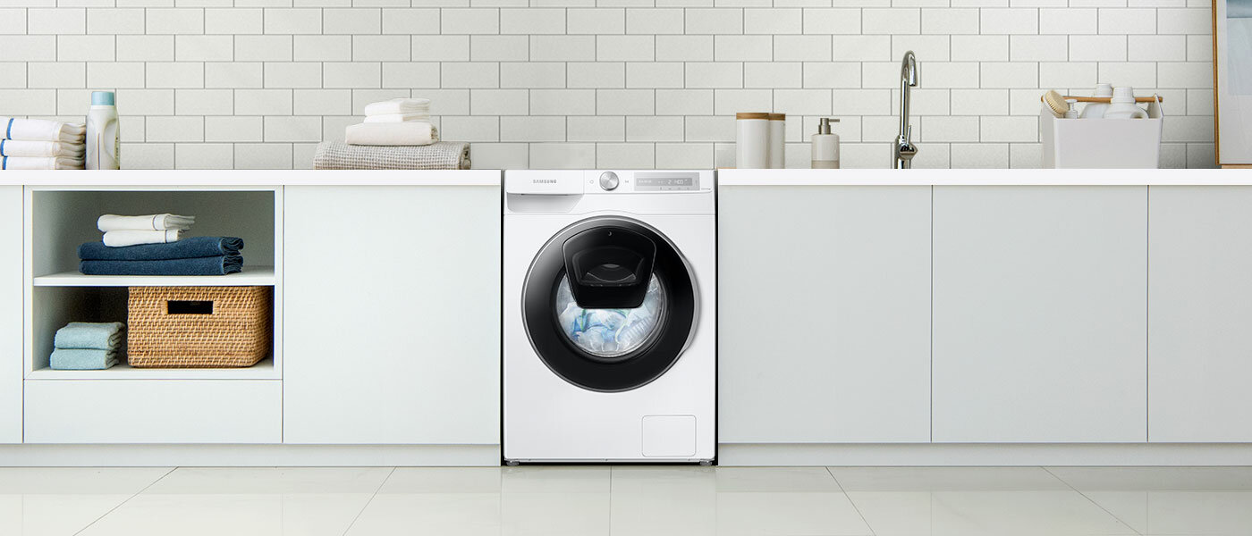 Pomieszczenie gospodarcze z pralką pełną kolorowego prania Pomieszczenie gospodarcze z pralką pełną kolorowego prania