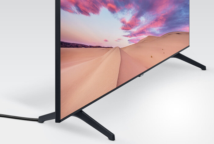 Ukryte kable telewizora stojącego w białej minimalistycznej przestrzeni Ukryte kable telewizora stojącego w białej minimalistycznej przestrzeni