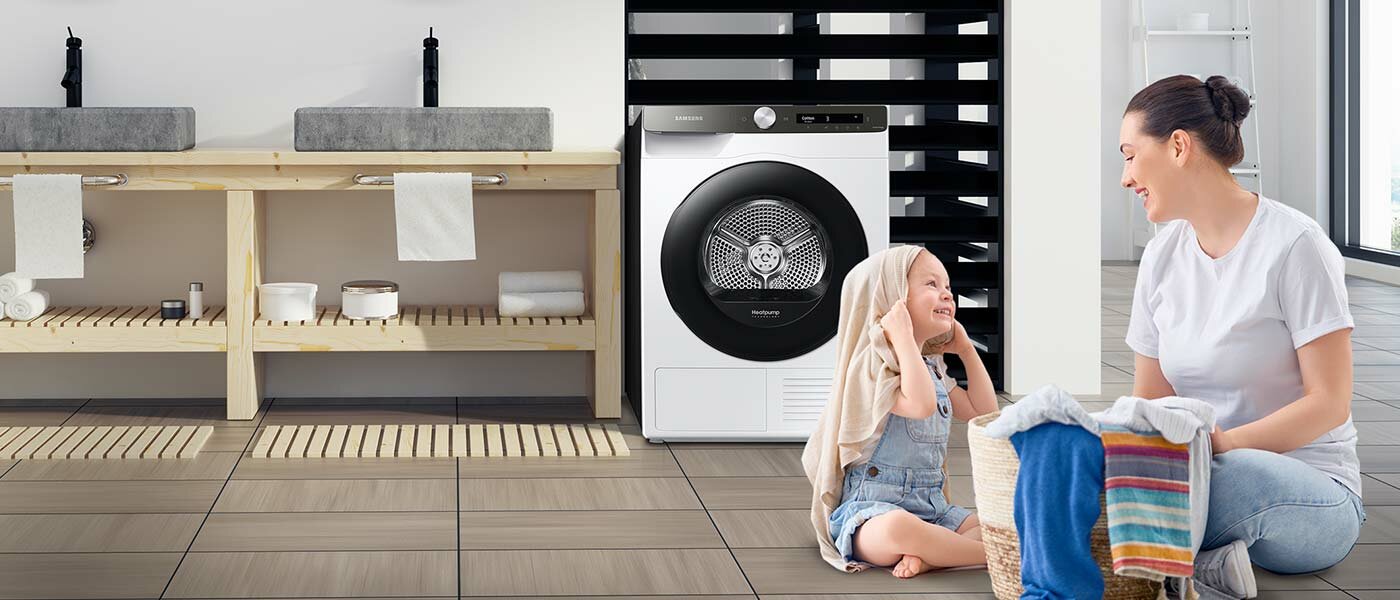 Rodzice z dzieckiem wyjmują wysuszone ubranie z suszarki Samsung Rodzice z dzieckiem wyjmują wysuszone ubranie z suszarki Samsung
