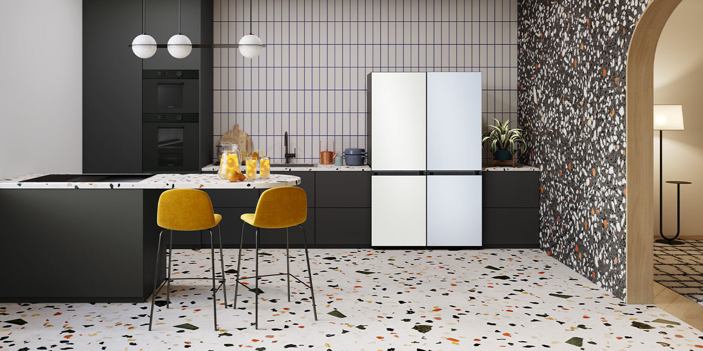 Zdjęcie nowocześnie urządzonej kuchni, w której znajdują się takie elementy wyposażenia jak żółte krzesła czy czarne piekarniki. W pomieszczeniu stoją również dwie lodówki z serii Samsung BESPOKE, które harmonijnie komponują się z otoczeniem. Zdjęcie nowocześnie urządzonej kuchni, w której znajdują się takie elementy wyposażenia jak żółte krzesła czy czarne piekarniki. W pomieszczeniu stoją również dwie lodówki z serii Samsung BESPOKE, które harmonijnie komponują się z otoczeniem.