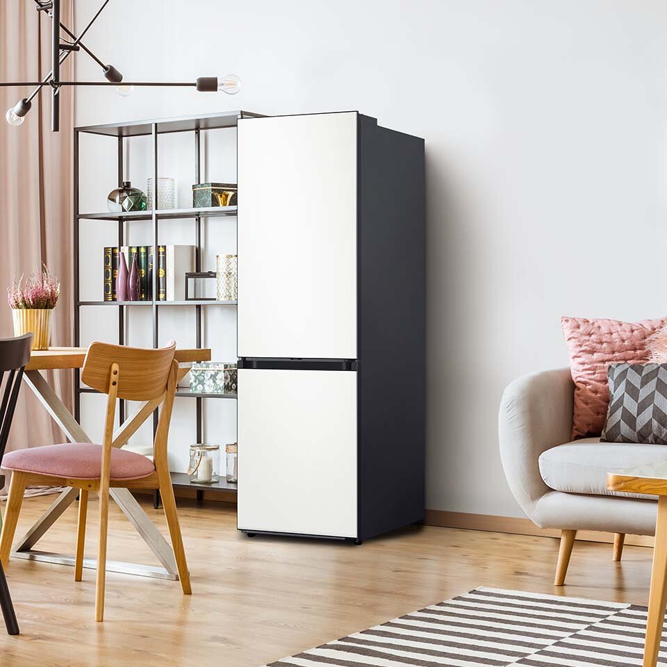 Ilustracja lodówki Samsung BESPOKE z frontem w kolorze alabastrowej bieli. Urządzenie stoi w pomieszczeniu dziennym z drewnianymi panelami podłogowymi. Ilustracja lodówki Samsung BESPOKE z frontem w kolorze alabastrowej bieli. Urządzenie stoi w pomieszczeniu dziennym z drewnianymi panelami podłogowymi.