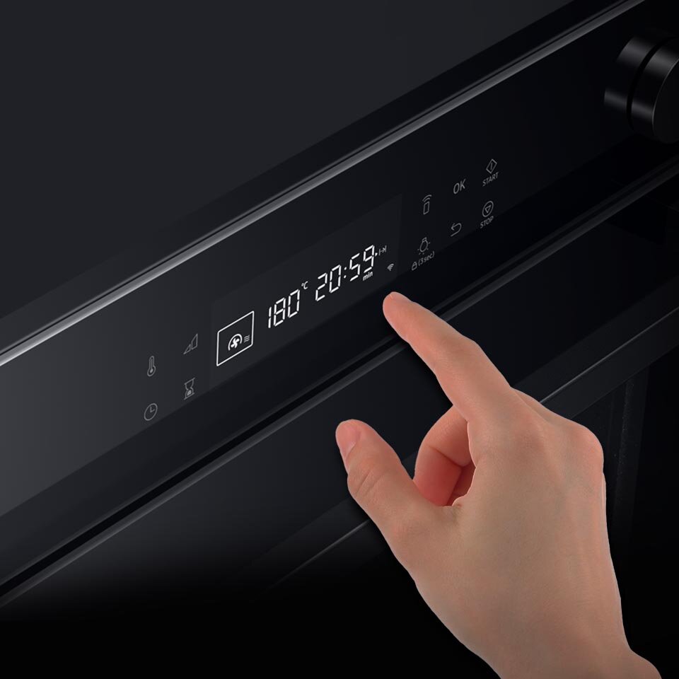 Dłoń obsługująca piekarnik kompaktowy, na wyświetlaczu, którego widać, że wybrano pieczenie z użyciem termoobiegu i mikrofal w temperaturze 180 stopni Dłoń obsługująca piekarnik kompaktowy, na wyświetlaczu, którego widać, że wybrano pieczenie z użyciem termoobiegu i mikrofal w temperaturze 180 stopni