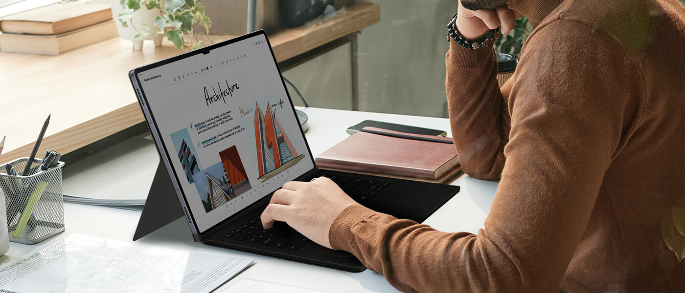 Mężczyzna korzysta z Galaxy Tab S10, trzymając dłoń na etui Book Cover Keyboard. Mężczyzna korzysta z Galaxy Tab S10, trzymając dłoń na etui Book Cover Keyboard.