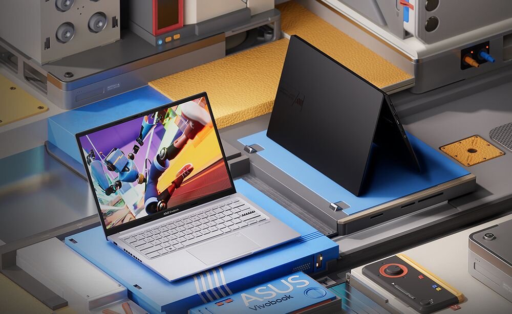 Laptop ASUS VivoBook 14X K3405 - Laptop umieszczony na stole, w towarzystwie różnych urządzeń elektronicznych, podkreślający technologiczną atmosferę. >
</div>
</div>
</div>
<div class=